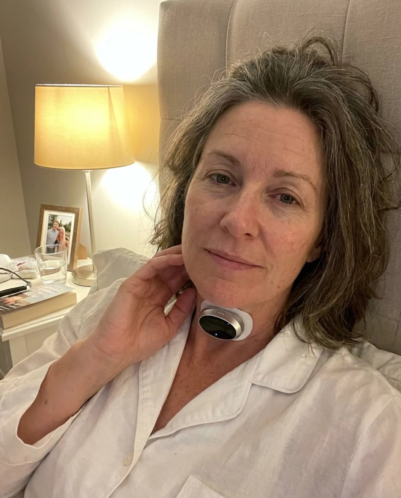 A woman wearing BreathePulse in bed at night