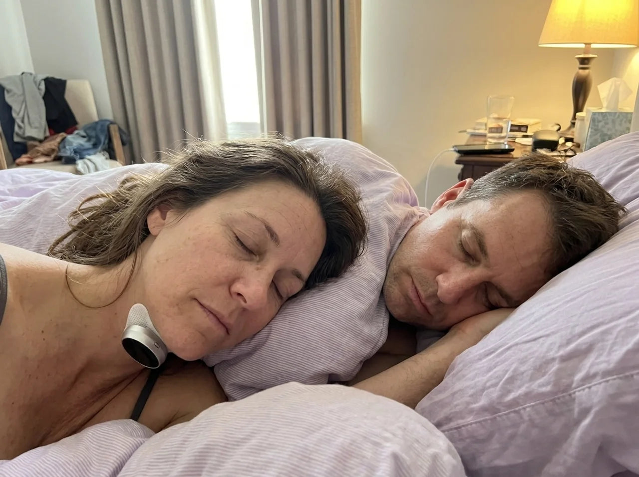 A woman sleeping peacefully beside her partner while wearing BreathePulse